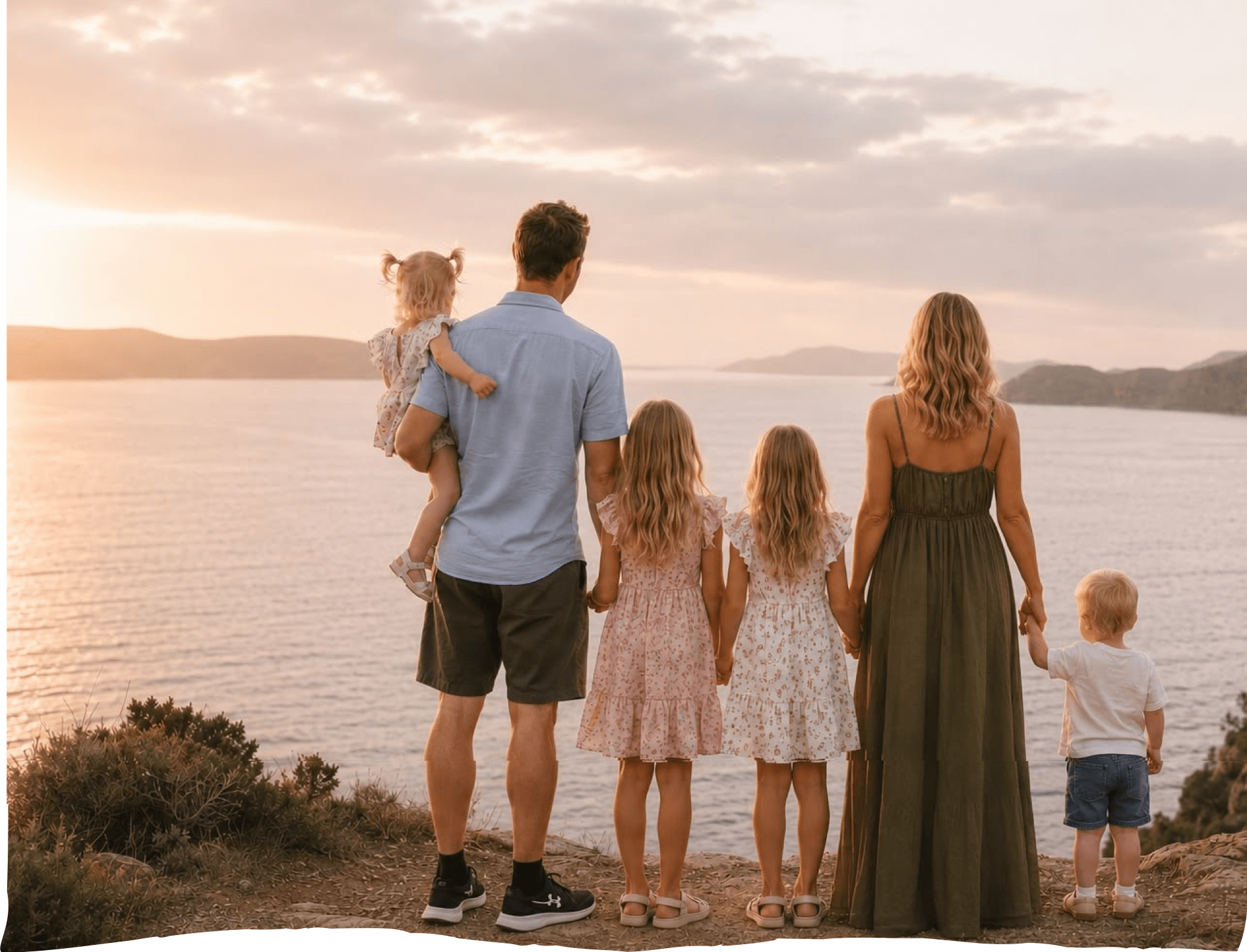 The Slade family standing together looking out over a beautiful coastline at sunset